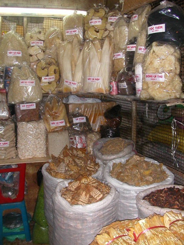 Ein Marktstand mit ordentlich verpackten Lebensmitteln in Tüten und Plastikabdeckungen, einschließlich anderer Gegenstände, die auf einen gut sortierten und organisierten Laden hinweisen.