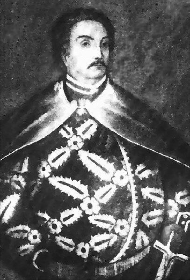 Schwarzes und weißes Foto von Papst Johannes Paul II. in Priesterrobe, der eine schwarze Robe mit weißem Kragen und Manschetten trägt und die Hände gefaltet hat, mit ernstem Gesichtsausdruck und direktem Blick auf den Betrachter.