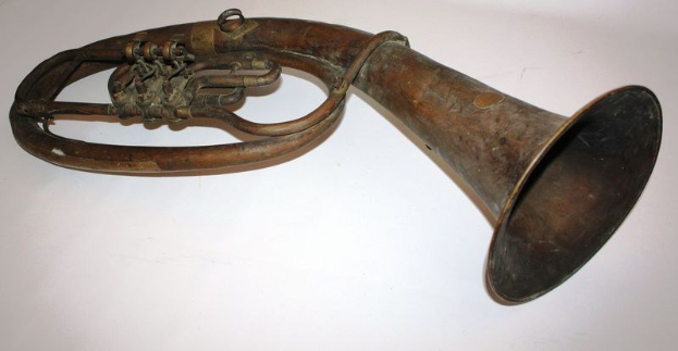 Alter Messinghorn mit glänzendem Finish, gebogenem Hals und aufgeblasenem Trichter, verziert mit detaillierten Gravuren auf einem weißen Hintergrund.