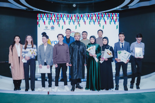 Gruppe von Menschen auf einer Bühne mit Blumensträuschen und Urkunden vor einem "Youth Solar Awards 2019"-Hintergrund.