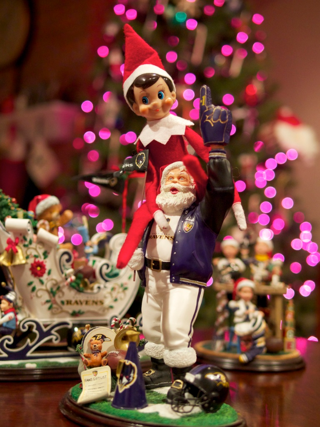 Spielfiguren stehen im Vordergrund mit einem beleuchteten Weihnachtsbaum im Hintergrund.