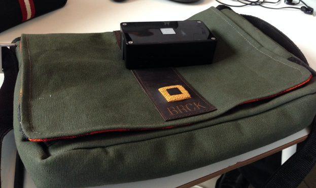 Eine Tasche und ein Paar Ohrhörer sind auf einem weißen Tisch platziert.