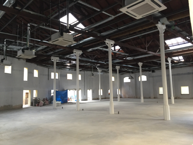 Industrielle Lagerhalle mit großen Fenstern, Säulen und Deckenbeleuchtung zur Miete verfügbar.