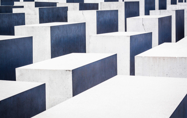 Ein Feld aus Betonplatten in verschiedenen Höhen, die in einem Gittermuster angeordnet sind, bekannt als Holocaust-Mahnmal für die ermordeten Juden Europas, befindet sich in Berlin, Deutschland.