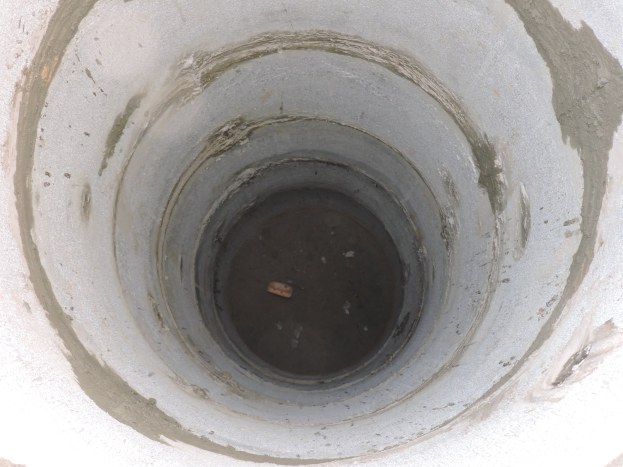 Betonsielrohr mit mittigem Loch in einer Betonwand und einem Objekt im Loch.