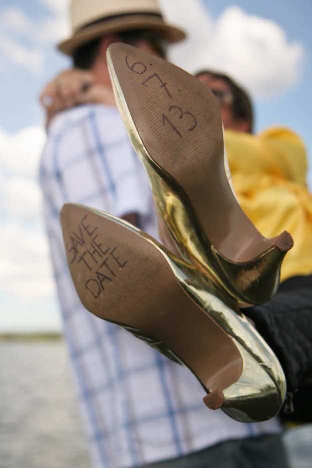 Frauen-Absätze mit Text darauf, mit einer Person, die die Beine einer Frau hinter den Absätzen hält.