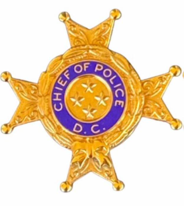 Polizeimarke mit der Aufschrift "Polizeipräsident" auf einem weißen Hintergrund.