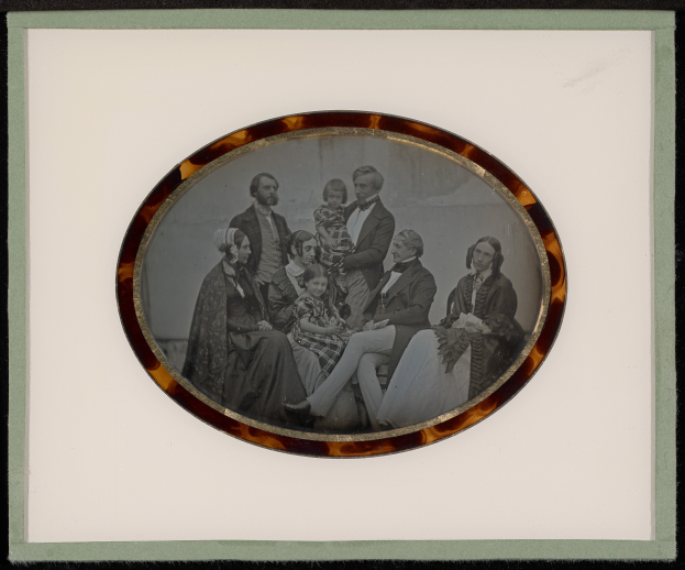 Ein Schwarz-Weiß-Foto einer Familie in festlicher Kleidung, gerahmt und posiert für ein Bild.