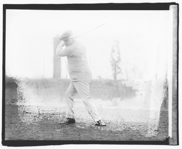 Schwarz-weiß-Foto eines Mannes, der einen Golfschläger auf dem Rasen schwingt, mit Bäumen im Hintergrund.