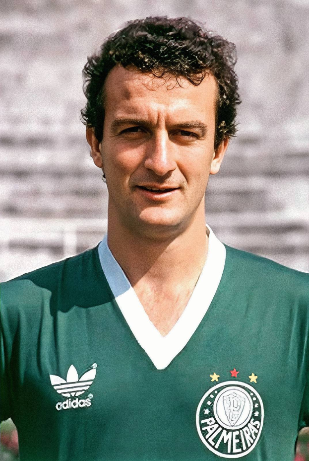 Ein Mann in einem grünen "Palmeiras"-T-Shirt mit "Diego Maradona"-Text vor einem unscharfen Stadion.